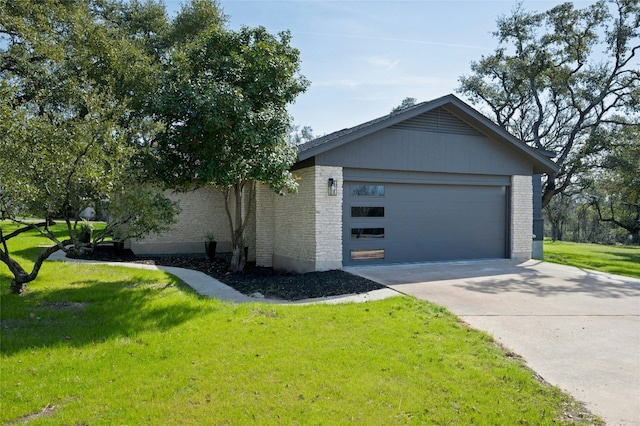 view of front of house featuring a front yard, brick siding, and driveway