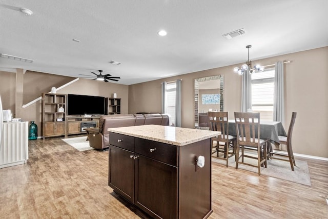 kitchen featuring ceiling fan with notable chandelier, dark brown cabinets, light wood-type flooring, and visible vents