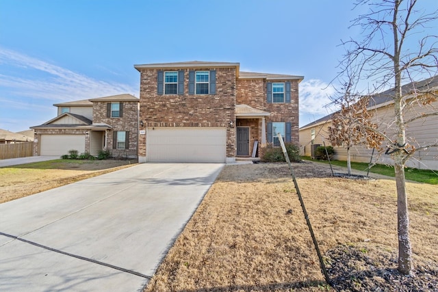 view of front of home with driveway, brick siding, an attached garage, and fence