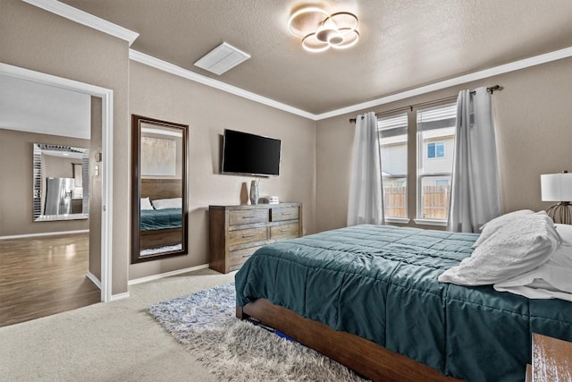 carpeted bedroom featuring stainless steel fridge, a textured ceiling, ornamental molding, and baseboards