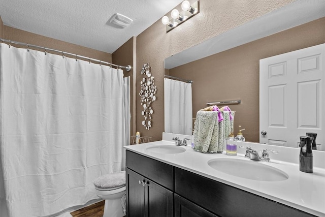 bathroom featuring a textured ceiling, visible vents, a sink, and toilet