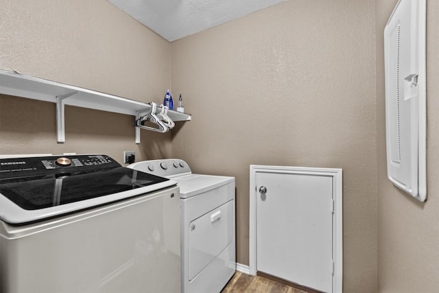 washroom featuring light wood-type flooring, laundry area, and separate washer and dryer