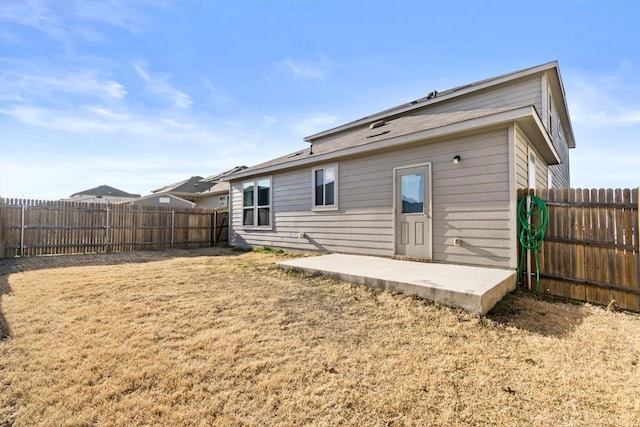 rear view of house with a patio, a yard, and a fenced backyard