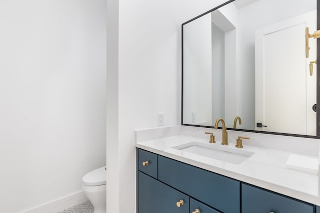 bathroom with toilet, baseboards, and vanity