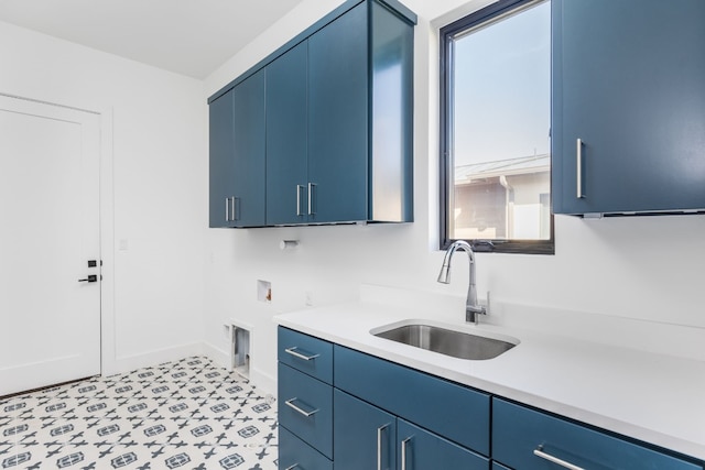 kitchen featuring baseboards, light countertops, a sink, and blue cabinetry