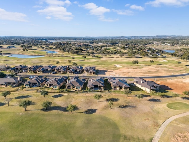 drone / aerial view with a residential view, view of golf course, and a water view