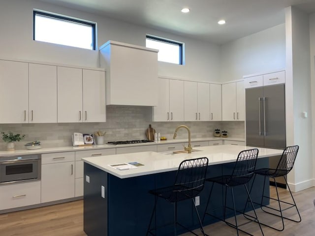 kitchen with stainless steel appliances, a breakfast bar area, a sink, and light countertops