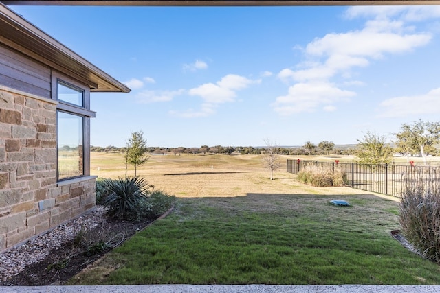 view of yard featuring fence and a rural view