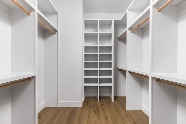 walk in closet with wood finished floors