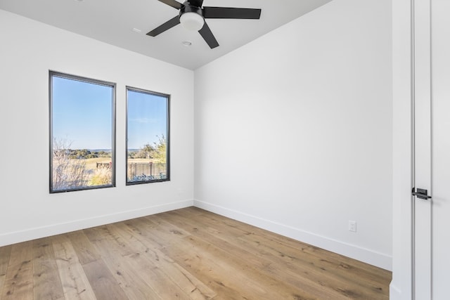 unfurnished room with light wood finished floors, baseboards, and a ceiling fan