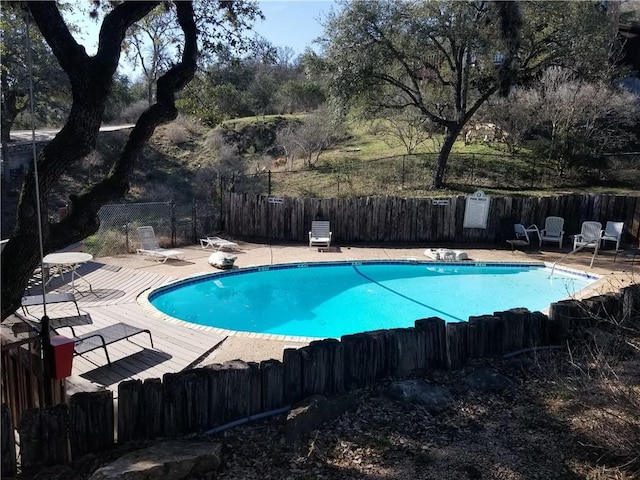 pool with a patio area and a fenced backyard