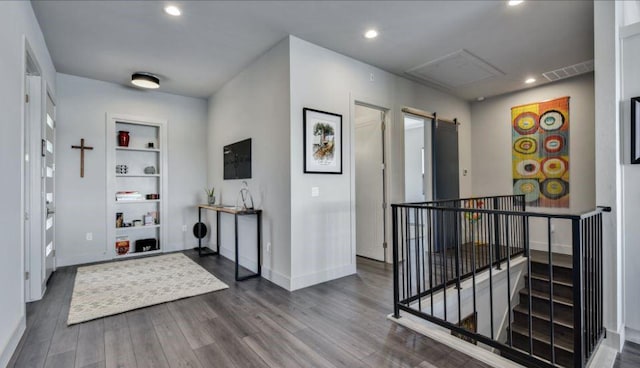 foyer with a barn door, wood finished floors, visible vents, and recessed lighting