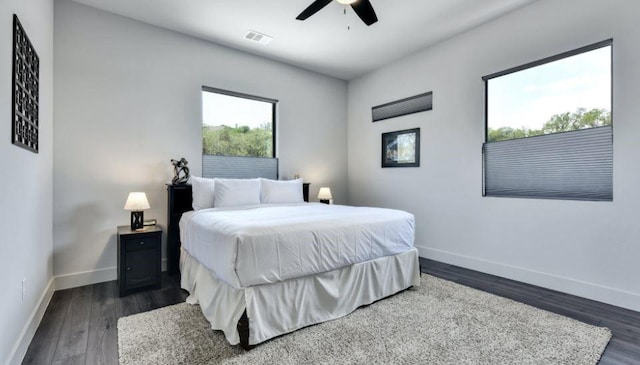 bedroom featuring baseboards, visible vents, dark wood finished floors, and a ceiling fan