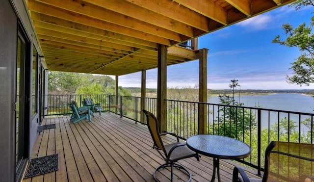 deck at dusk featuring a water view