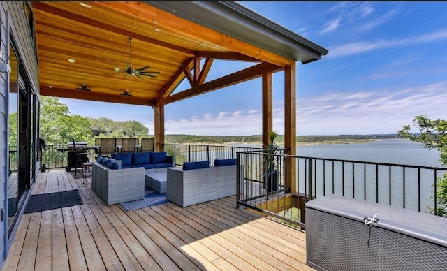 wooden terrace featuring a water view, outdoor lounge area, and a ceiling fan