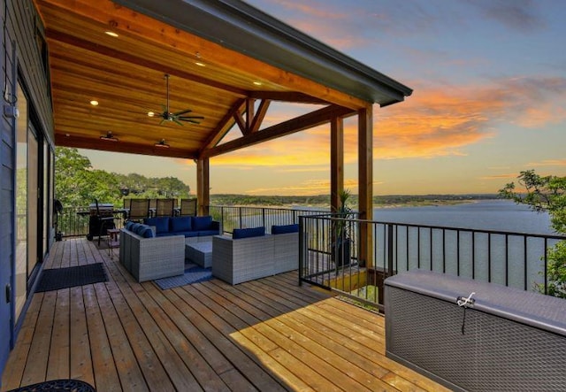 deck featuring a ceiling fan, a water view, and an outdoor hangout area