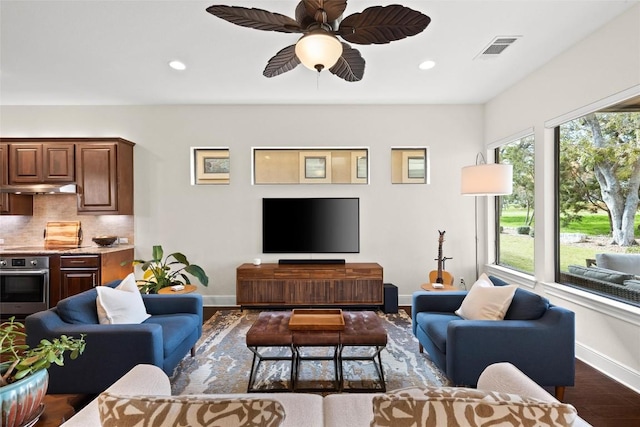 living area with recessed lighting, dark wood finished floors, visible vents, and baseboards