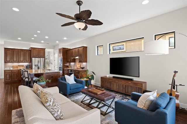 living area featuring a ceiling fan, baseboards, recessed lighting, and dark wood-style floors