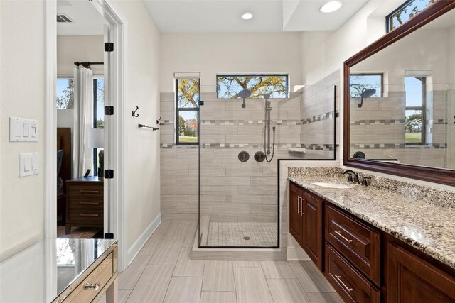 bathroom with vanity, recessed lighting, baseboards, a shower stall, and visible vents