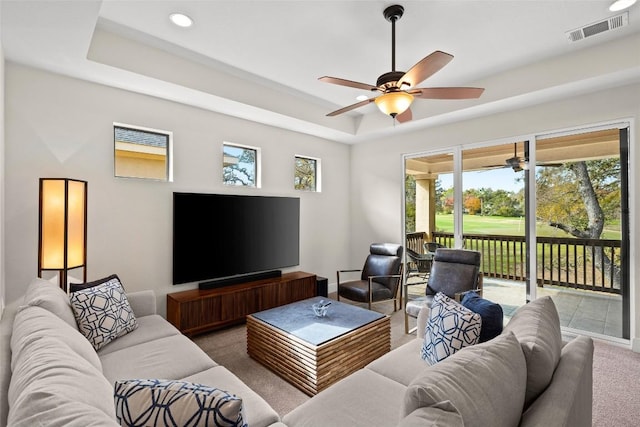 carpeted living area featuring recessed lighting, a raised ceiling, visible vents, ceiling fan, and baseboards