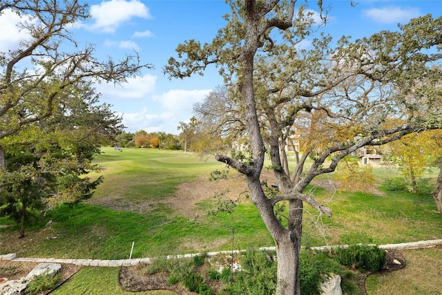surrounding community featuring golf course view and a yard