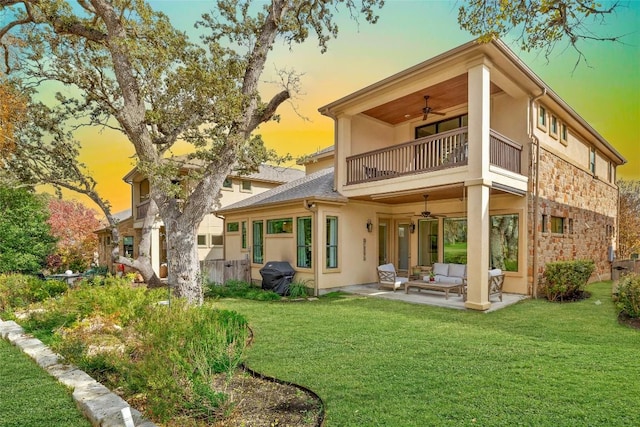 back of house featuring ceiling fan, a patio area, a balcony, and stucco siding