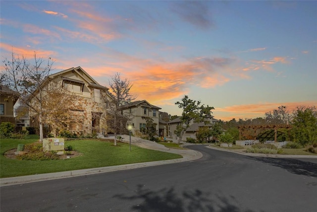 view of front of home with driveway, a front lawn, and stone siding