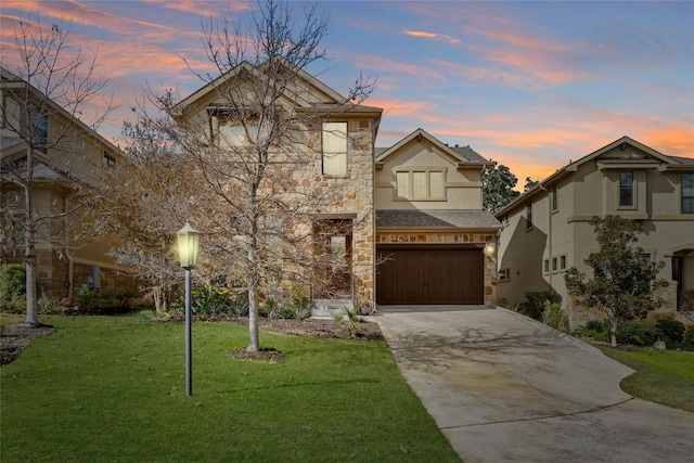 traditional home with an attached garage, stone siding, stucco siding, a yard, and driveway