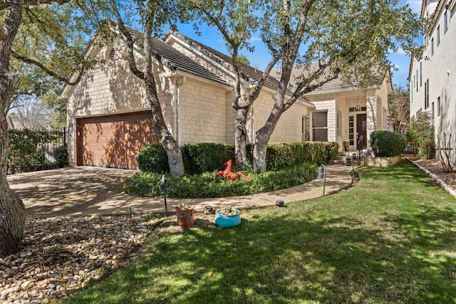 view of front of home featuring driveway, a front lawn, and an attached garage