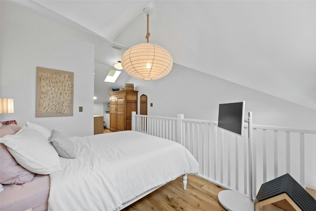 bedroom with visible vents, vaulted ceiling, and wood finished floors