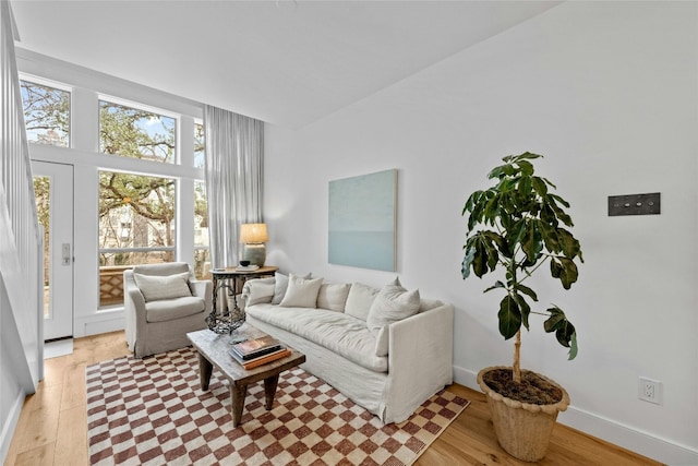 living area with light wood-type flooring and baseboards