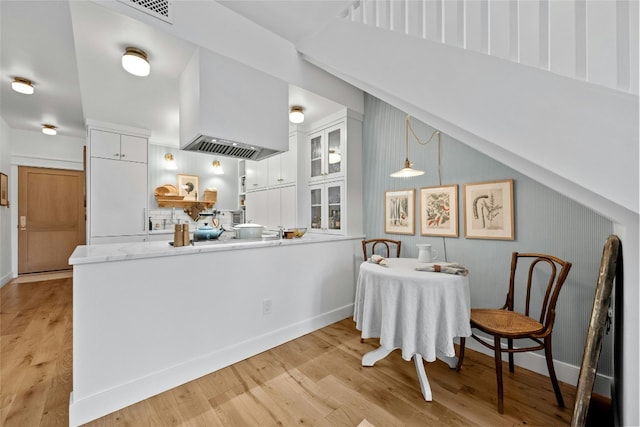 kitchen with light wood-style floors and white cabinets