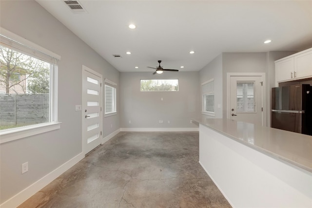 6902 Carver Ave Unit B, Austin, TX 78752 - kitchen featuring freestanding refrigerator, recessed lighting, concrete flooring, baseboards, and white cabinetry