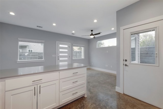 6902 Carver Ave Unit B, Austin, TX 78752 - kitchen with finished concrete flooring, white cabinets, baseboards, recessed lighting, and light countertops
