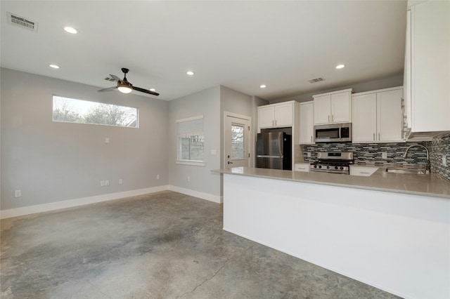 6902 Carver Ave Unit B, Austin, TX 78752 - kitchen featuring stainless steel appliances, a sink, concrete flooring, backsplash, and a peninsula