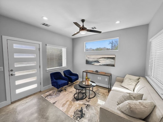 living area featuring baseboards, visible vents, concrete flooring, and recessed lighting