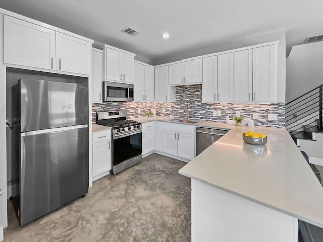 6902 Carver Ave Unit B, Austin, TX 78752 - kitchen featuring appliances with stainless steel finishes, a peninsula, a sink, finished concrete floors, and light countertops