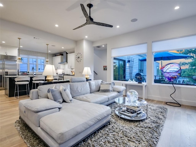 living room with recessed lighting, baseboards, ceiling fan, and light wood finished floors