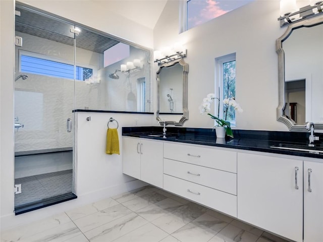 full bath featuring plenty of natural light, marble finish floor, a sink, and a shower stall