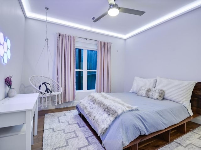 bedroom featuring wood finished floors, visible vents, and a ceiling fan