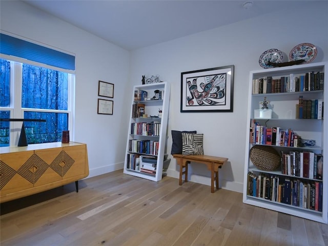 living area featuring baseboards and wood finished floors