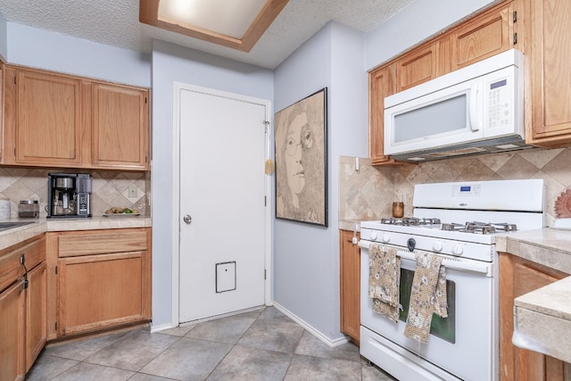 kitchen featuring white appliances, decorative backsplash, light countertops, a textured ceiling, and light tile patterned flooring