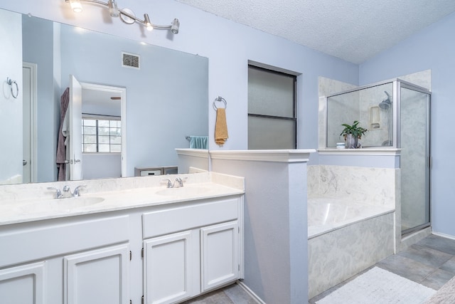 full bath featuring visible vents, a sink, a shower stall, and a textured ceiling