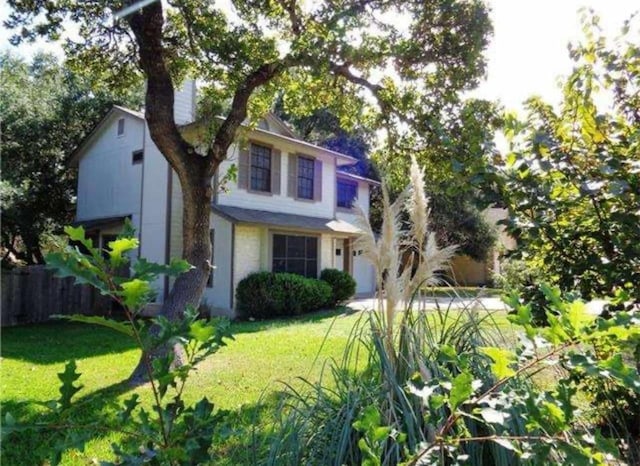 view of front facade featuring a garage, fence, and a front lawn