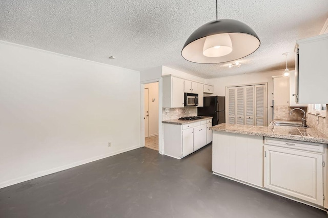 kitchen featuring a sink, white cabinets, decorative backsplash, black appliances, and finished concrete floors