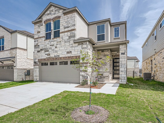 view of front of home with driveway, stone siding, an attached garage, central air condition unit, and a front lawn