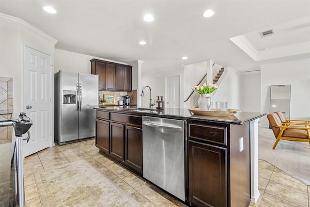 kitchen featuring dark countertops, dark brown cabinetry, stainless steel appliances, and a sink