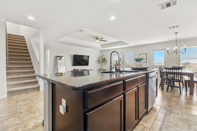 kitchen with a tray ceiling, visible vents, a sink, and stainless steel dishwasher