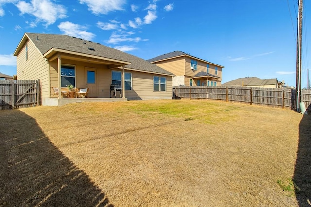 back of property with a patio area, a fenced backyard, and a yard