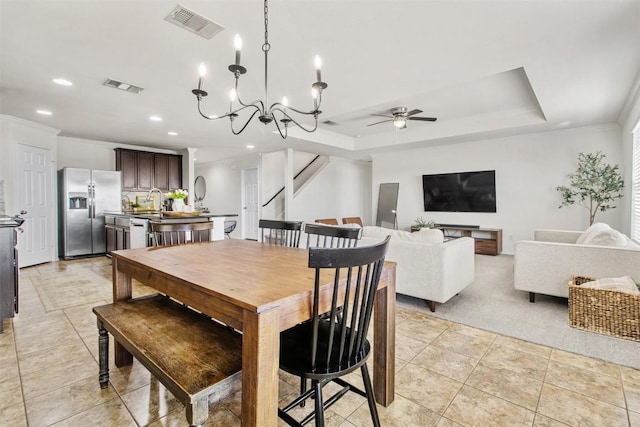 dining area featuring a tray ceiling, stairs, visible vents, and crown molding